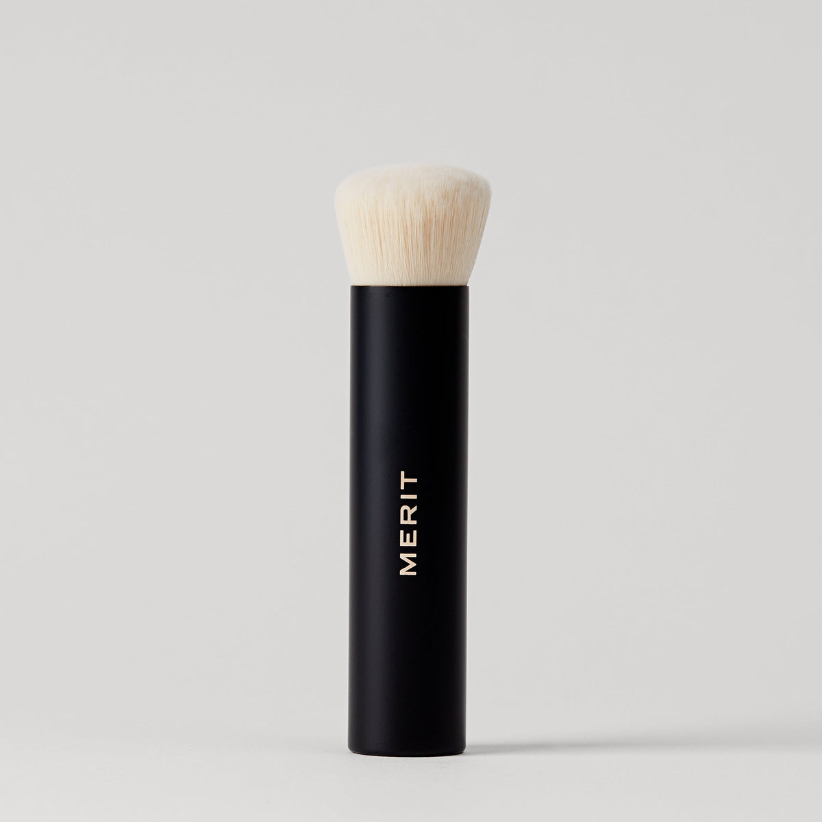 Master || A  black makeup brush with a white bristle head, standing upright