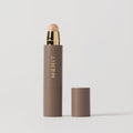 Master || A stick complexion product with MERIT written on it, with the cap removed, showing the product in shade Bisque.