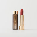 Master ||  A tube of lipstick in shade Court with a gold and brown cap next to its open container