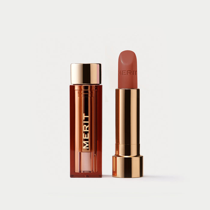 Master ||  A tube of lipstick in shade ginger with a gold and brown cap next to its open container