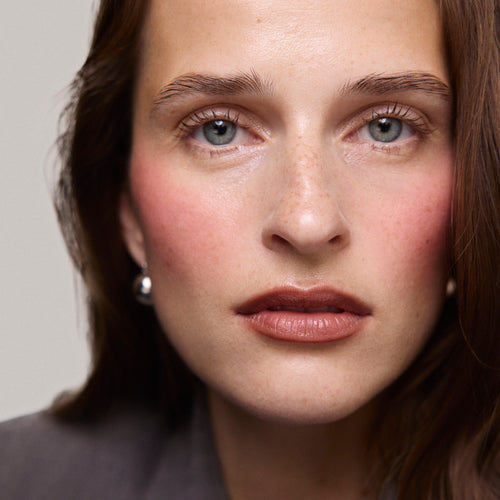 Rouge| face::fair | Model is wearing Flush Balm in shade Rouge.